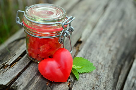 clear glass airtight jar beside heart decor on wood thumbnail