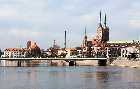photo of brown and green church beside river thumbnail
