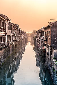 river surrounded with concrete houses at daytime thumbnail