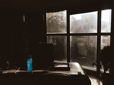 Blue Plastic Tumbler on Wooden Table Beside Chair in Room thumbnail