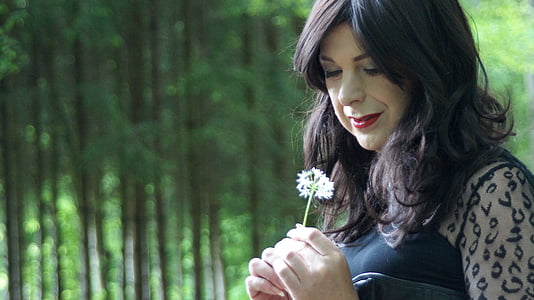 woman holding white petaled flower during daytime thumbnail