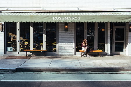 woman sitting on bench beside the building thumbnail