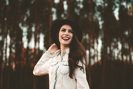 smiling woman wearing white denim jacket in selective focus photography thumbnail