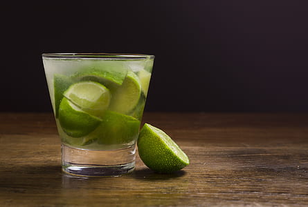 shot glass filled with liquid and slice lime thumbnail