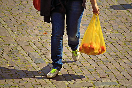 person holding yellow plastic bag thumbnail