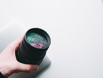 person holding camera lens thumbnail