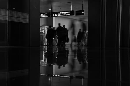 grayscale photo of people standing under light signage thumbnail