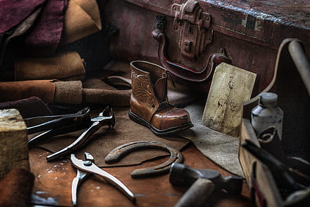 brown leather boot and gray pliers beside brown case thumbnail