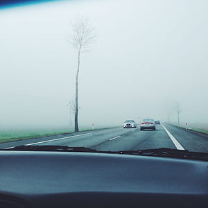 vehicles on road covered with fog thumbnail