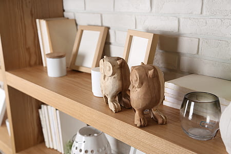 brown bird figurines near photo frames on wooden shelf thumbnail