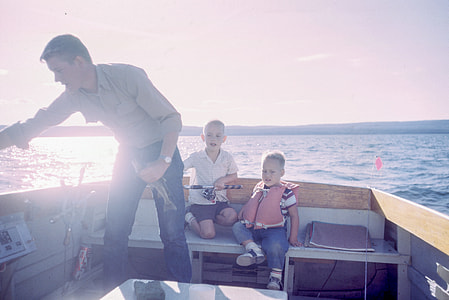 man and two boys riding motorboat during daytime thumbnail