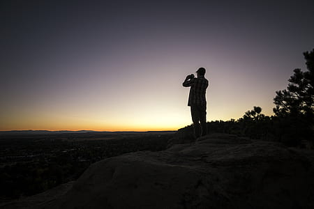 silhouette photography of man standing on plant thumbnail