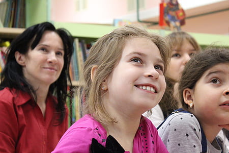 girl wearing pink and black shirt looking above smiling thumbnail