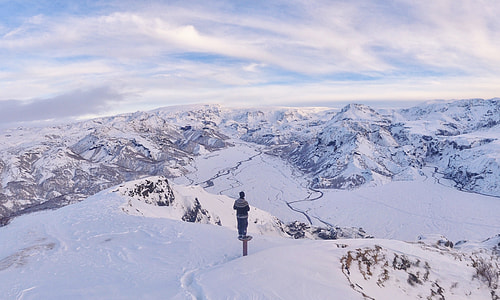 person standing on mountain filled with snow thumbnail
