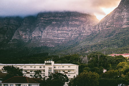 white building near mountains thumbnail