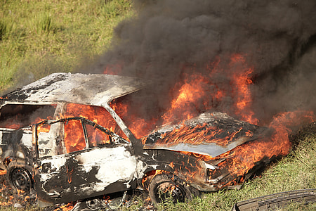 white car under fire on green grass during daytime thumbnail