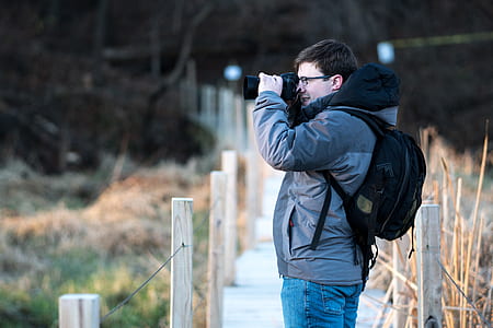 man taking photo near bridge thumbnail
