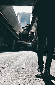 man standing on pavement holding device thumbnail
