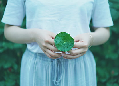 woman standing holding leaf thumbnail