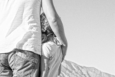 grayscale photography of person holding girl thumbnail