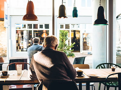 man sitting on chair beside table thumbnail