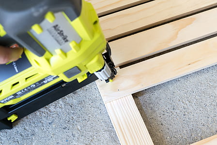 person holding yellow and black power tool thumbnail
