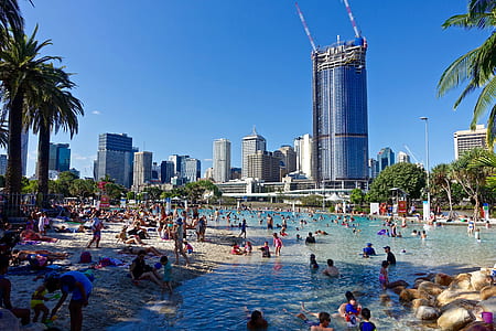 people swimming on beach near building thumbnail