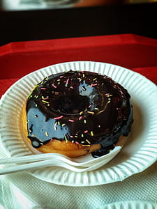 Chocolate Donut Above Round Paper Plate and Plastic Spoon and Fork thumbnail