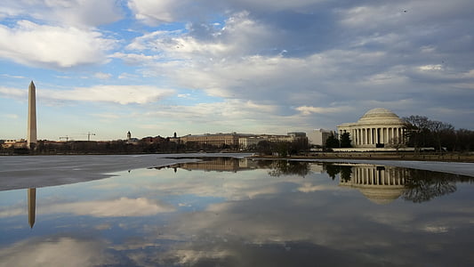 Monument near lake under white clouds during daytime thumbnail