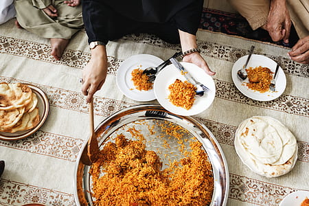 person getting food from a tray to plate on a dining table thumbnail