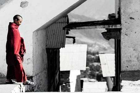 selective color photo of graphy of man walking near building thumbnail