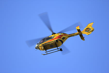 low angle photographed of flying yellow helicopter thumbnail