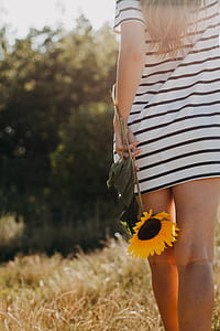woman holding sunflower photo thumbnail