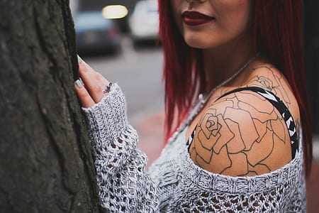 woman in gray knitted sweater standing beside tree trunk thumbnail