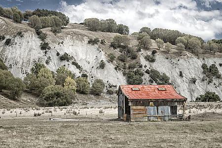 red and brown house beside of mountain thumbnail