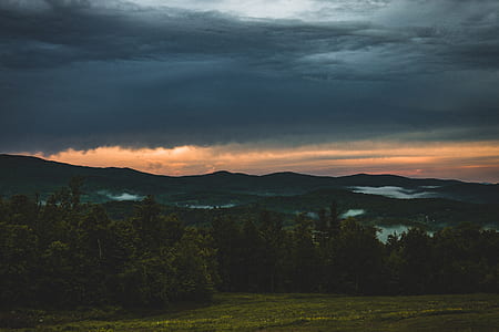 mountain under orange and gray skies thumbnail