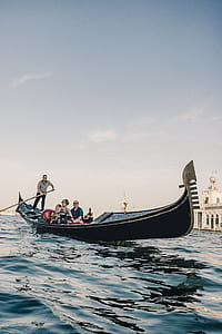 group of people riding on black boat on body of water during daytime thumbnail