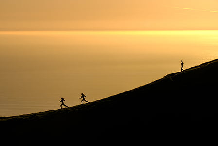silhouette of three person near body of water at sunset thumbnail