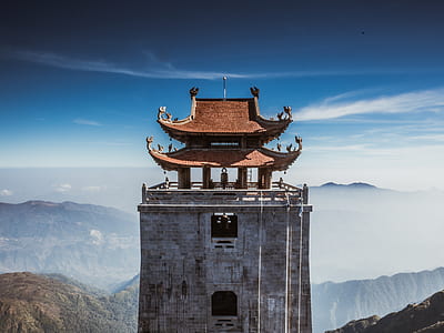 black and red concrete temple overlooking mountain at daytime thumbnail