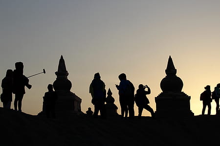 silhouette of people and statues at sunset thumbnail