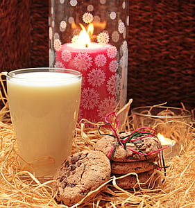 chocolate chip cookies beside glass of milk and red pillar candle thumbnail