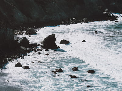 waves bashing on rocky seashore at daytime thumbnail