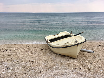 beige boat near sea shore thumbnail