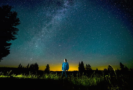 man standing on grass under starry night thumbnail
