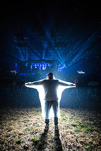 man spreading his arms with light on his back thumbnail
