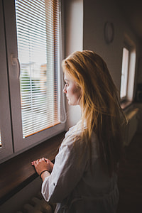 woman beside brown wooden windowsill thumbnail