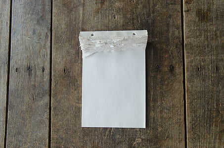 white paper on brown wood plank surface thumbnail