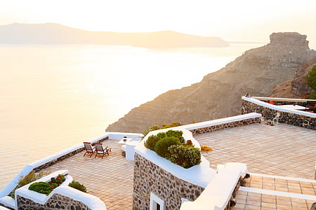 two black steel chairs on balcony overlooking body of water thumbnail