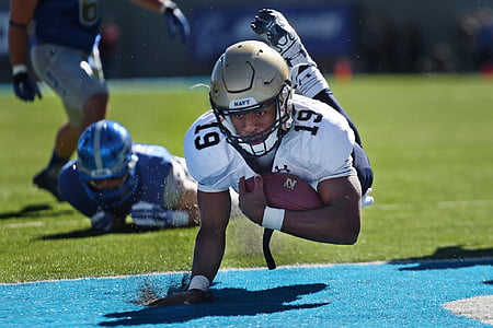 man carrying NFL ball on field thumbnail
