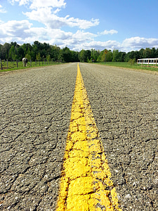 yellow line on gray top road at day time thumbnail